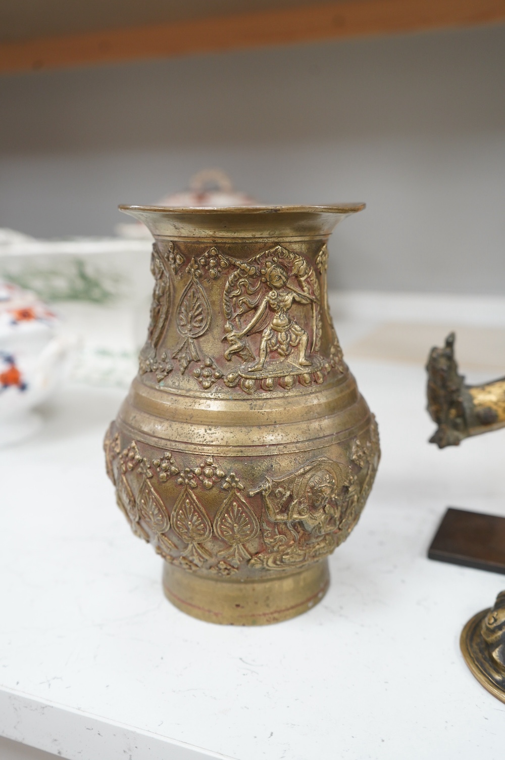 An 18th century Tibetan gilt copper repoussé fragment, a relief decorated vase and an appliqué, largest 26cm long. Condition - fair, as per the images